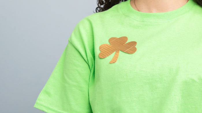 A green t-shirt with a gold shamrock on it.