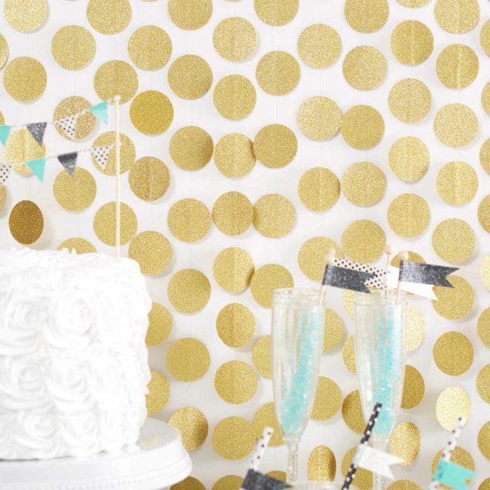 A gold glitter back drop made of garlands.